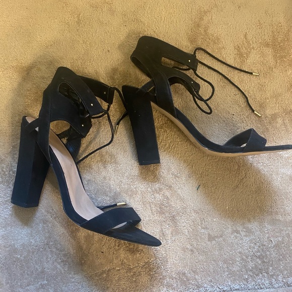 Shoes - These are a pair of open toed black heels. With a shoe lace strap up